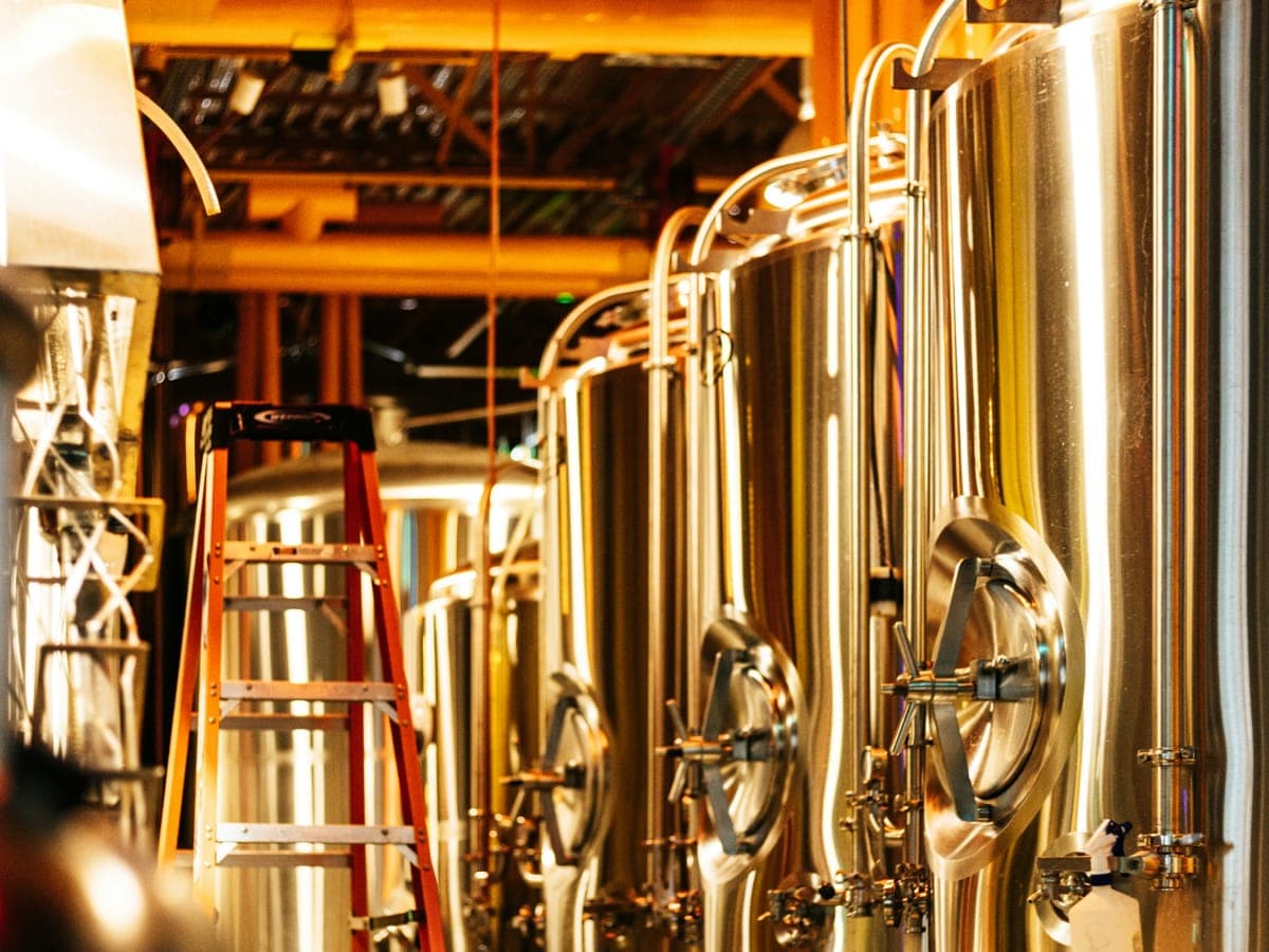 Row of stainless steel fermentation tanks in a brewery